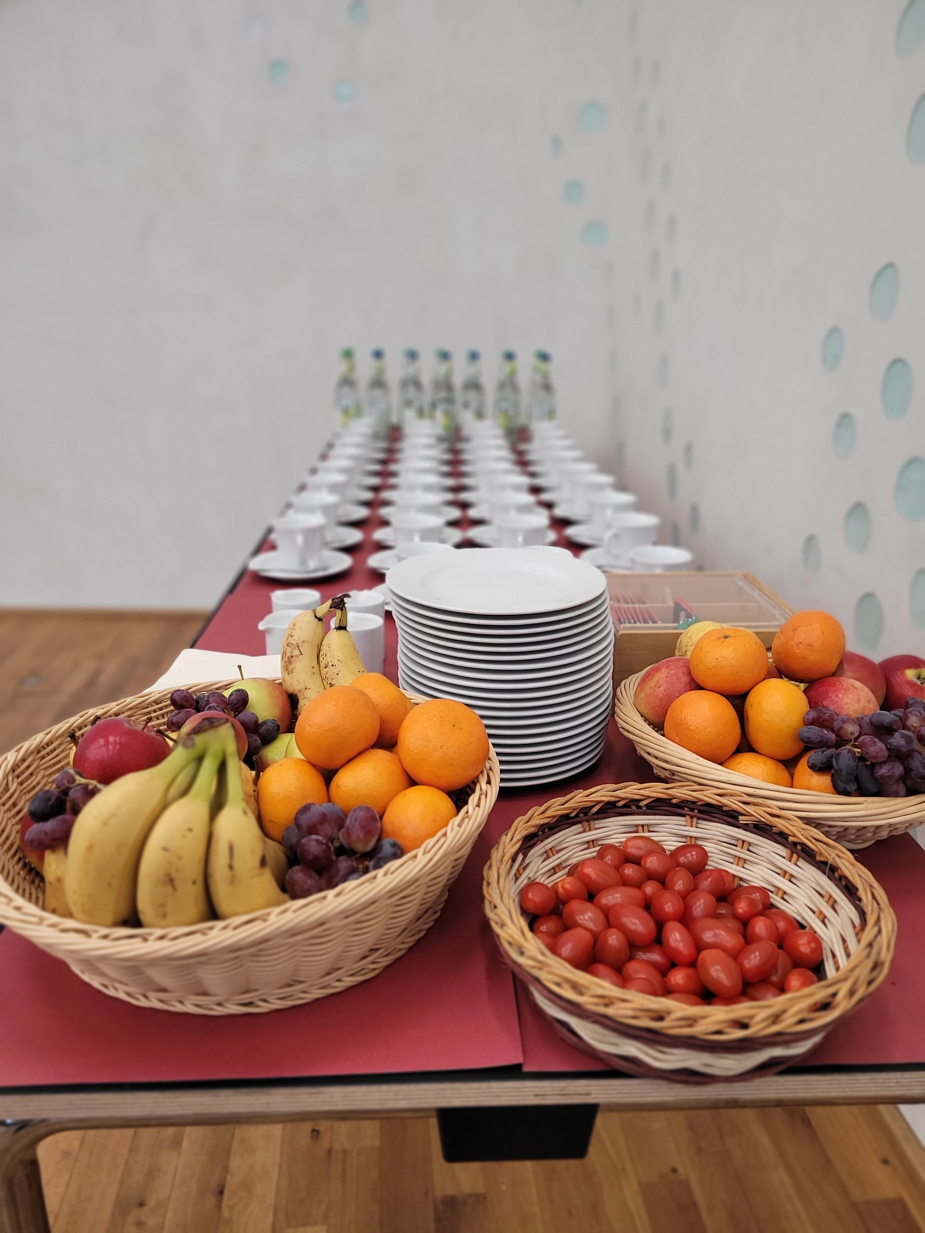 Tisch mit Getränken, Kaffeetassen und Obstkörben